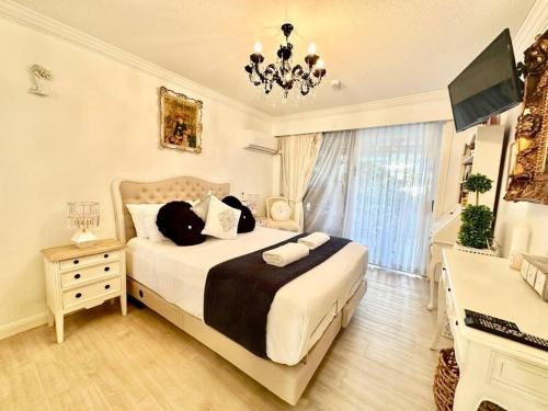 a bedroom with a large bed and a chandelier at French provincial style, Phoenician Broadbeach in Gold Coast