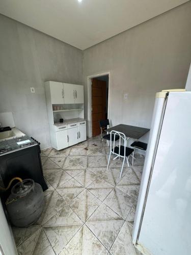 a small kitchen with a table and a refrigerator at Kitnet mobiliada em Parauapebas in Parauapebas