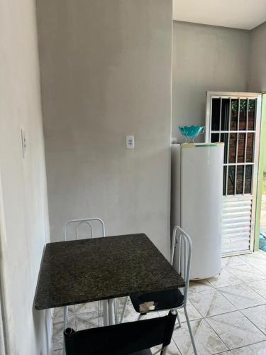 a table and chairs in a kitchen with a refrigerator at Kitnet mobiliada em Parauapebas in Parauapebas