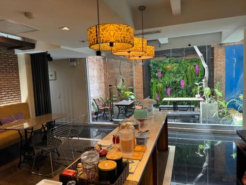 a room with tables and chairs and a large window at Silom Convent Garden in Bangkok