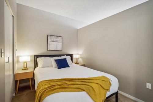 Un dormitorio con una cama con una manta amarilla. en CozySuites Mill District pool gym # 03, en Minneapolis