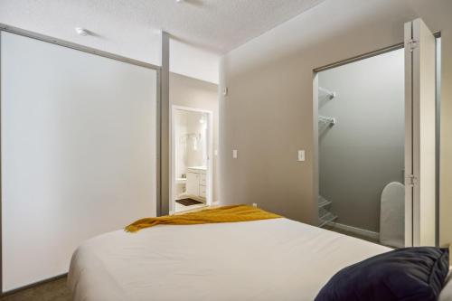 a bedroom with a white bed and a large mirror at CozySuites Mill District with pool, gym #03 in Minneapolis