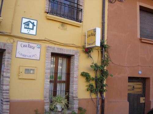 a yellow building with a sign on the side of it at Casa Rural "La Bardena Blanca I " in Arguedas