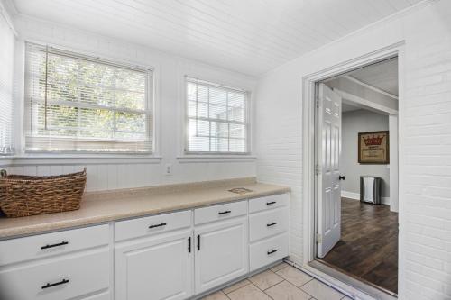 cocina blanca con armarios blancos y ventana en Forest Hills Cottage en Augusta