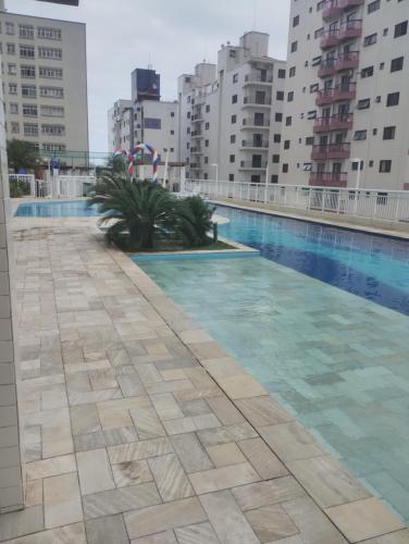 linda vista mar,2 quartos,Ocian SP في برايا جراندي: مسبح وسط بعض المباني