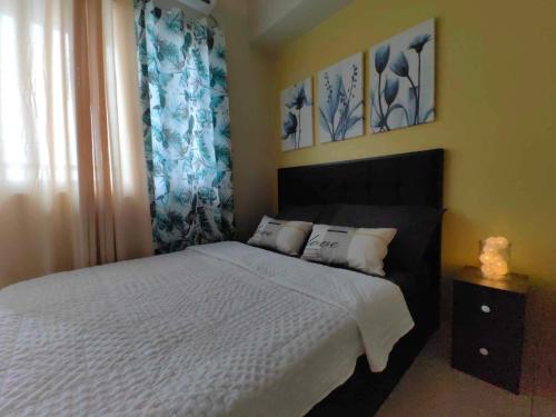a bedroom with a bed with blue and white curtains at Condo Near MOA, NAIA, PICC, & CCP that is comfy with a view! in Manila