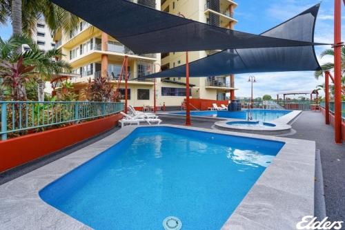 einem Pool an der Seite eines Gebäudes in der Unterkunft Cullen Bay Resorts in Darwin