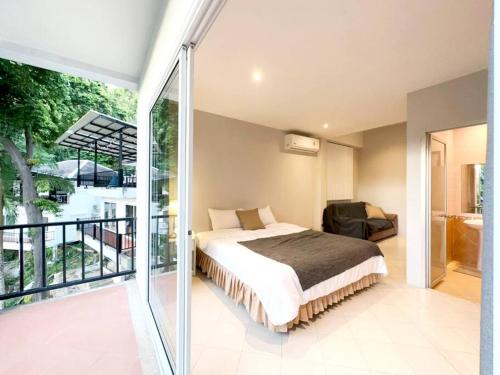 a bedroom with a bed and a balcony at Prime Hill , Kathu Phuket / F3 in Phuket Town