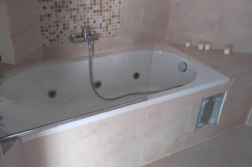 een badkamer met een bad en een douche bij appartement de luxe haut standing les falaises in Oran