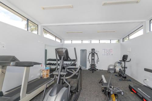 a gym with treadmills and exercise bikes in a room at Sovereign Pier On The Waterways in Whitianga