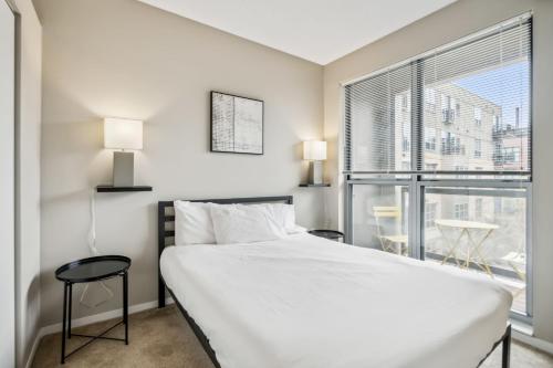 a bedroom with a bed and a large window at CozySuites Mill District pool gym # 06 in Minneapolis