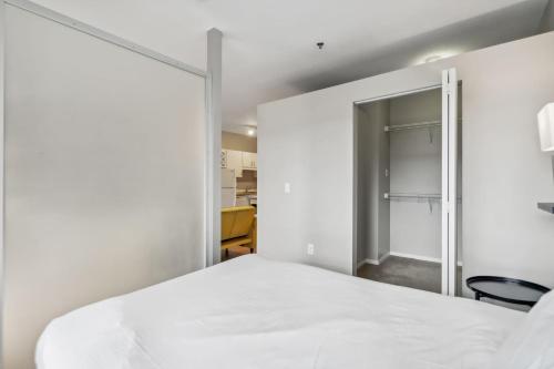 a bedroom with a white bed and a sliding glass door at CozySuites Mill District with gym #06 in Minneapolis