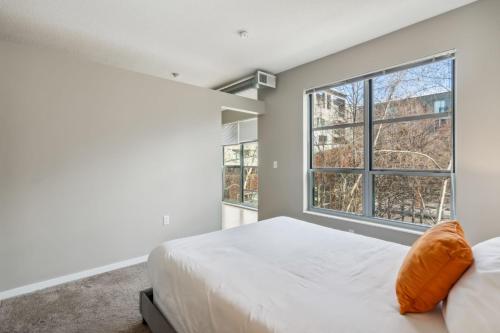 a bedroom with a bed and a large window at CozySuites Mill District pool gym # 08 in Minneapolis