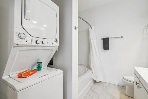 a white bathroom with a toilet and a sink at CozySuites Mill District with pool, gym #08 in Minneapolis