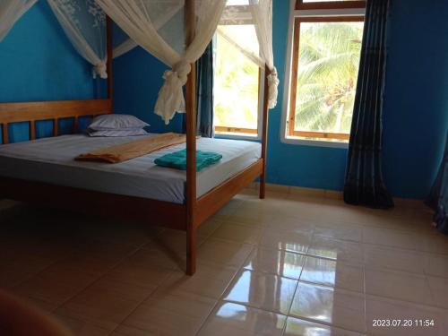 a bedroom with a canopy bed with a window at Sera Beach Dive Resort in Kododa