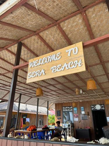 a sign hanging from the roof of a restaurant at Sera Beach Dive Resort in Kododa