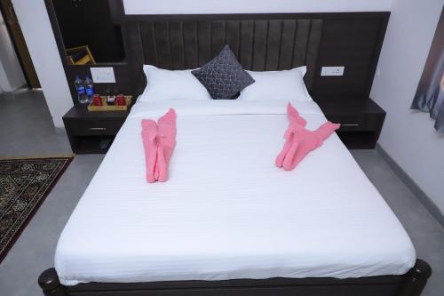 dos zapatos rosas están sentados en una cama blanca en Rajwada Fort en Dabok