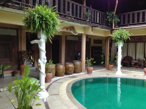 a swimming pool in front of a house at Ruean Thai Hotel in Sukhothai