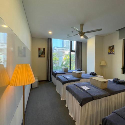 a row of beds in a room with a window at Danaciti Hotel in Danang