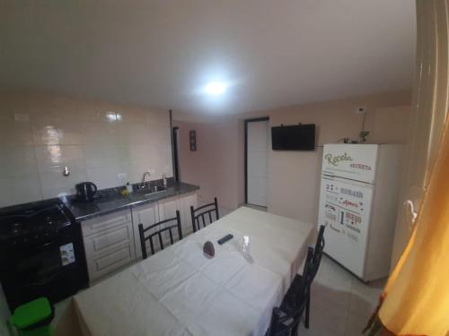 a kitchen with a table and a white refrigerator at La Aldea in Rodeo de la Cruz