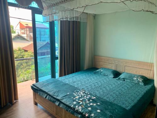 ein Schlafzimmer mit einem Bett und einem großen Fenster in der Unterkunft Home Hưng Trang in Diện Biên Phủ