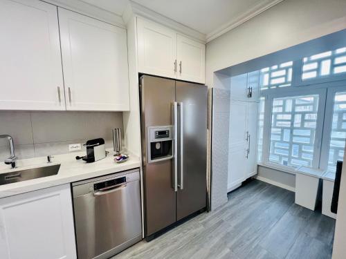 eine Küche mit einem Kühlschrank aus Edelstahl und weißen Schränken in der Unterkunft Antonio’s Captain Apartment - 200m from the beach in Peniche