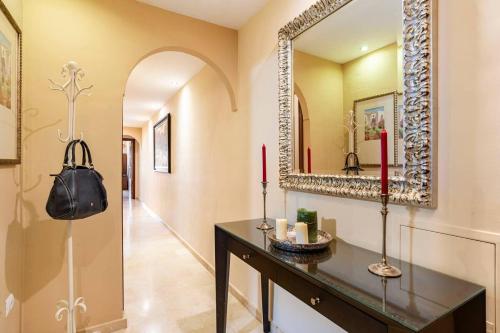 a hallway with a table with two candles and a mirror at Tu hogar en Ronda, la Ciudad Soñada in Ronda
