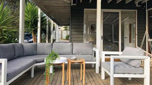 a patio with a couch and a table and chairs at The Birkdale with Heated Pool by Ready Set Stay - BYO Linen and Towels in Sunset Strip