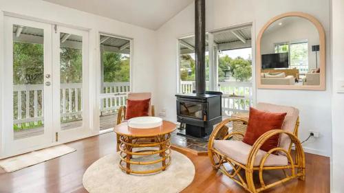a living room with a wood stove and chairs at The Birkdale with Heated Pool by Ready Set Stay - BYO Linen and Towels in Sunset Strip