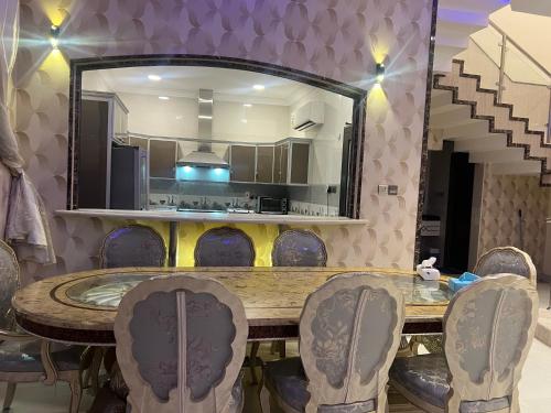 jadalnia ze stołem, krzesłami i lustrem w obiekcie Glory Resort w mieście Al Ahsa