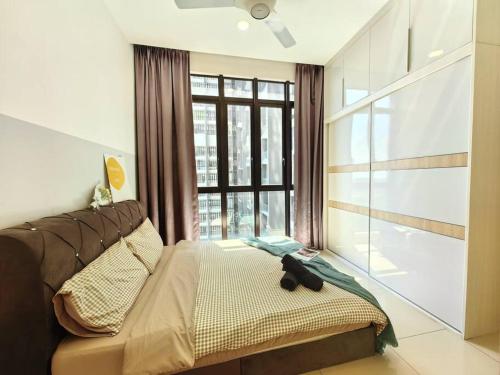 a bedroom with a bed with a cat sitting on it at D'Pristine 1512A walk to Legoland Netflix bySTAY in Nusajaya