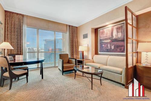 a living room with a couch and a table at MGM Signature-32-607 F1 Track & Strip View Balcony in Las Vegas