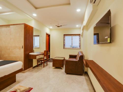 a room with a bed and a desk and a chair at Super Collection O SRP LUXURY ROOMS in Hyderabad