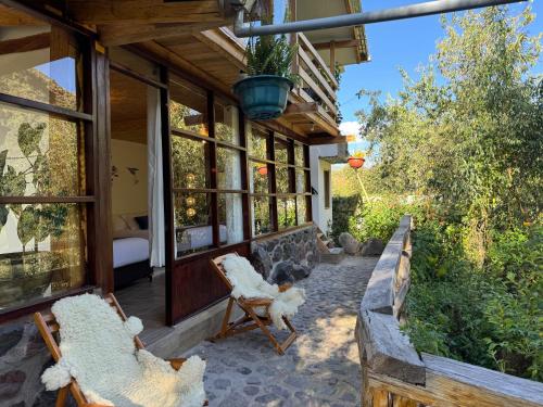 - une terrasse couverte avec 2 chaises et des fenêtres dans l'établissement Spirit Of The River Lodge, à Cusco