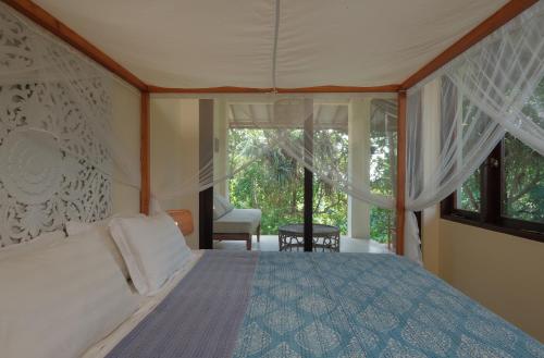 a bedroom with a bed and a large window at Ashtari - Sky, Sea & Nature in Kuta Lombok