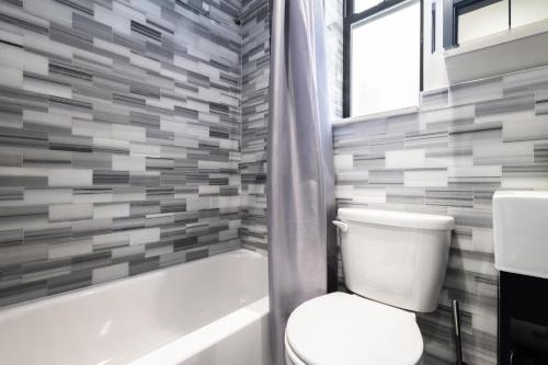 W łazience znajduje się toaleta, wanna i umywalka. w obiekcie Spacious 4BD Gem in Manhattan w Nowym Jorku