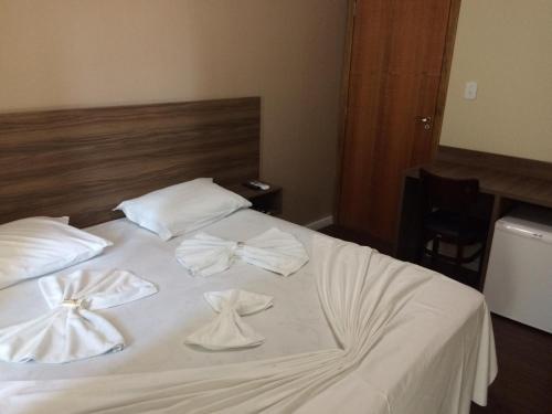 a white bed with two white towels on it at Cristal Park Hotel in Cristalina