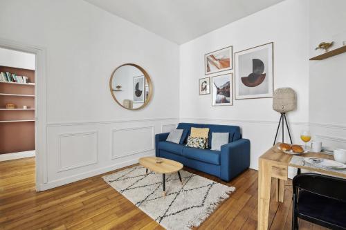 een woonkamer met een blauwe bank en een tafel bij Le Marais & Arts et Métiers - CityApartmentStay in Parijs