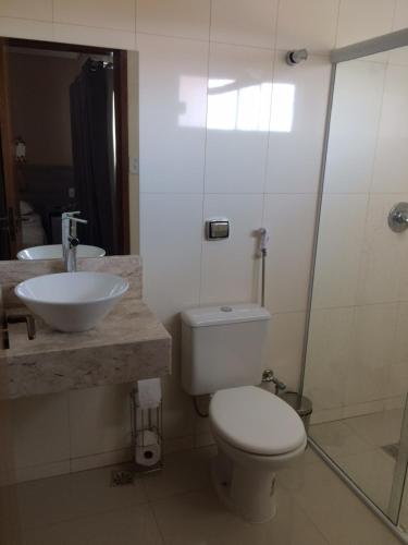 a bathroom with a toilet and a sink and a shower at Cristal Park Hotel in Cristalina