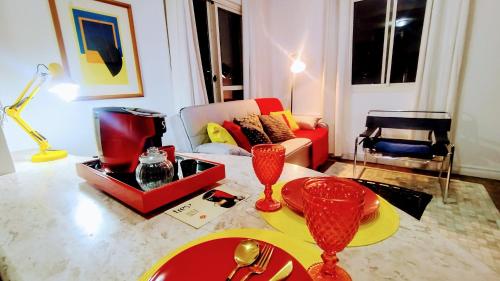 a living room with a couch and a table with wine glasses at Hotel Funchal JK - Itaim BiBi - Urban Duplex Deluxe Studio - First Class - Collors Edition - By HouseNN in Sao Paulo