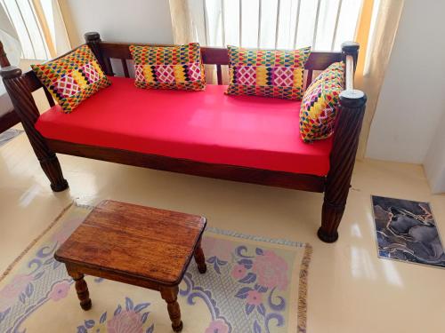 a bench with pillows and a table in a room at Happiness House in Shela
