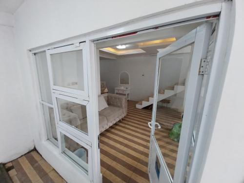 a room with a glass door with a couch inside at Villa kumudini's in Dieng