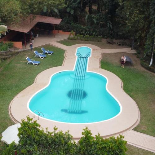 a swimming pool with a guitar in the middle at Arcadia Cabañas Vacacionales in Retalhuleu