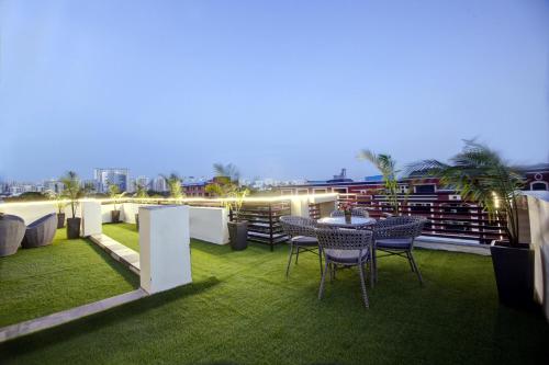 a patio with a table and chairs on a roof at Limewood Stay Golf Course Road in Gurgaon