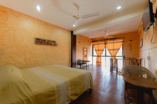Nopalero Suites Hostel في بويرتو إسكونديدو: غرفة نوم بسرير وطاولة وكراسي