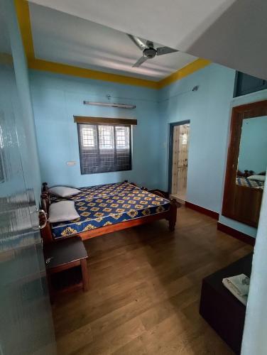 a bedroom with a bed in a room with blue walls at Park View in Mysore