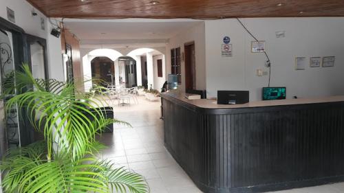 un vestíbulo con recepción y una planta en Hotel La Nueva Casa del viajero, en Aguachica