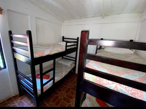 a room with three bunk beds in a room at Arcadia Cabañas Vacacionales in Retalhuleu
