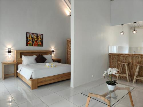 um quarto com uma cama e uma mesa de vidro em Alam Cottage Uluwatu em Uluwatu