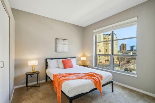 a bedroom with a bed and a large window at CozySuites Mill District pool gym # 11 in Minneapolis